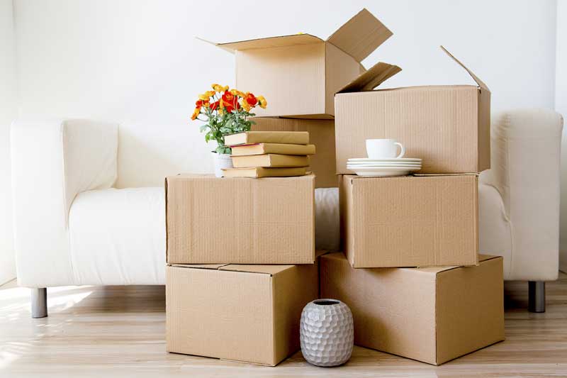 a stack of moving boxes in front of a couch