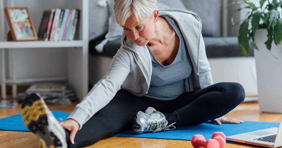 senior woman stretching on a yoga mat