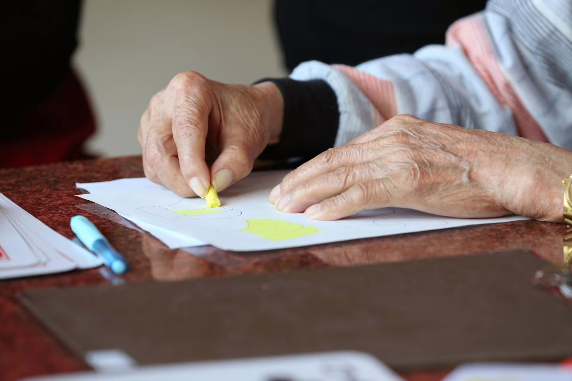 Senior participating in a hands-on activity during a memory care program at Friendship Village Tempe.