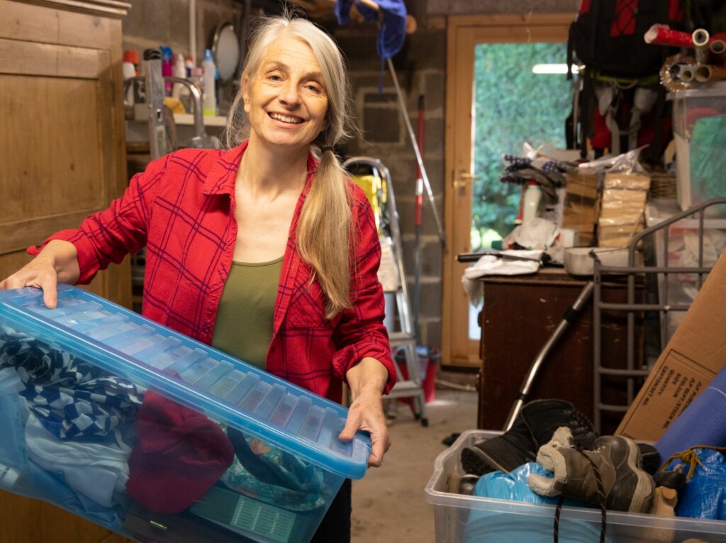 A senior woman is cleaning out her storage area and getting ready to move