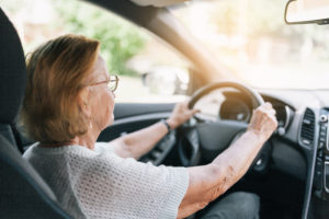 Senior woman driving to a retirement community